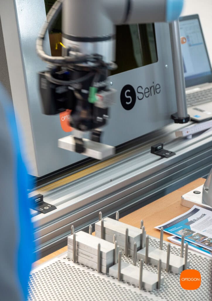 Im Bereich der industriellen Fertigung kommen zunehmend Laser und kollaborierende Roboter, auch als Cobots bezeichnet, zum Einsatz. Eine Möglichkeit ist die automatische Zuführung von Aluminium-Bauteilen in eine Laseranlage, wo sie vollautomatisch und präzise mit Laser beschriftet und graviert werden. Dabei können auch mehrere Seiten bearbeitet werden. Nach Abschluss des Prozesses wird das Bauteil wiederum automatisch vom Cobot aus der Laseranlage ausgeführt.