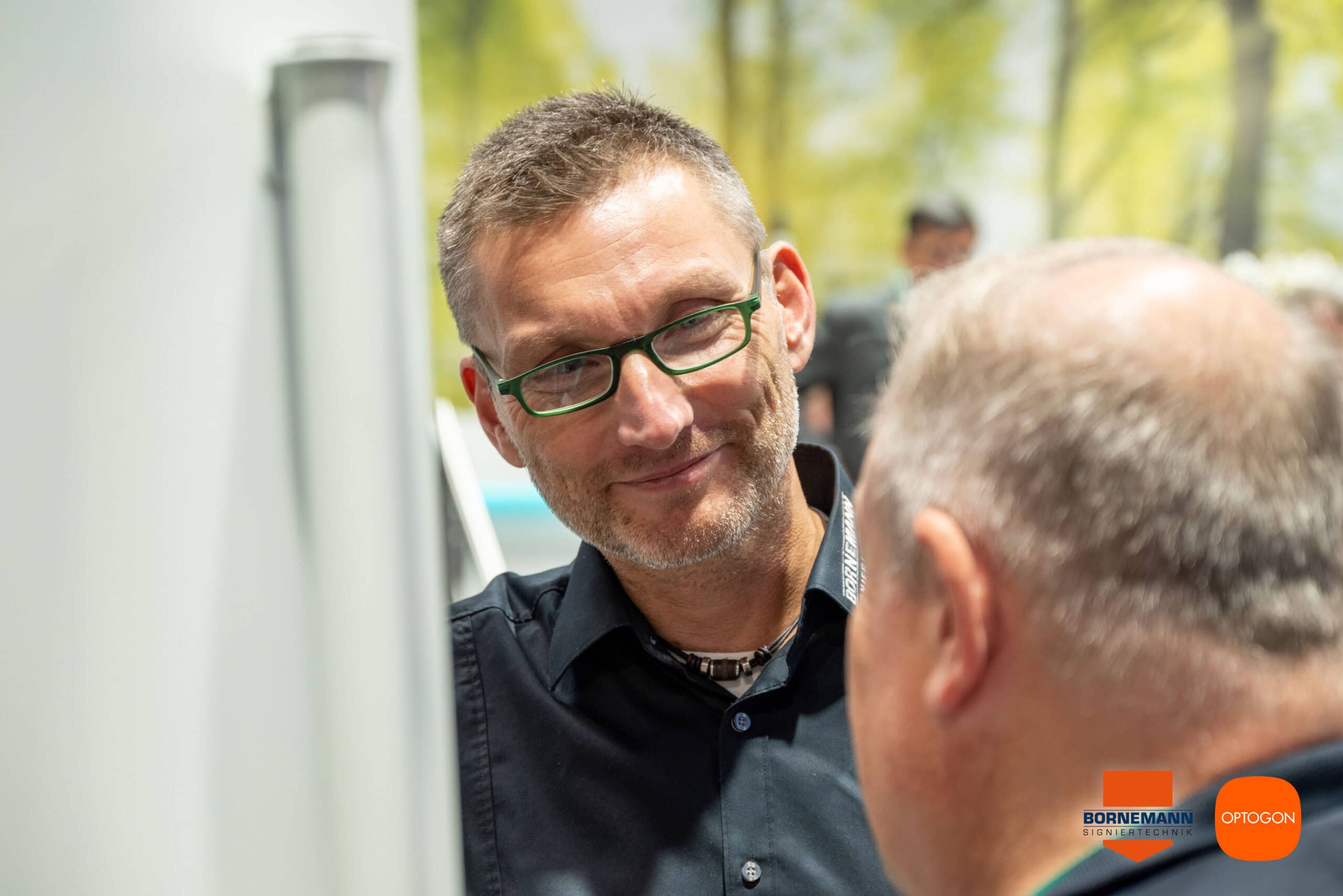 Roland Wilhelm im Gespräch auf der K-Messe vor der OPTOGON-Laseranlage.