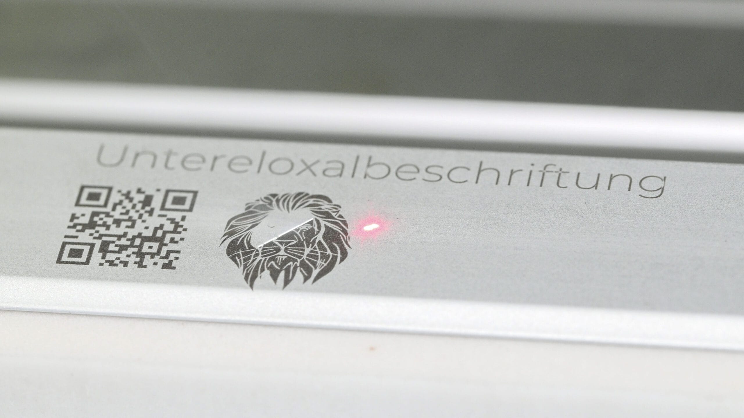 Laserprozess zur Untereloxalbeschriftung auf EV1 eloxiertem Aluminium bei OPTOGON.